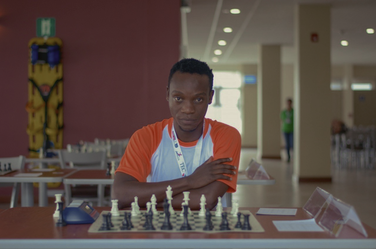 A man is sitting at a table playing chess.