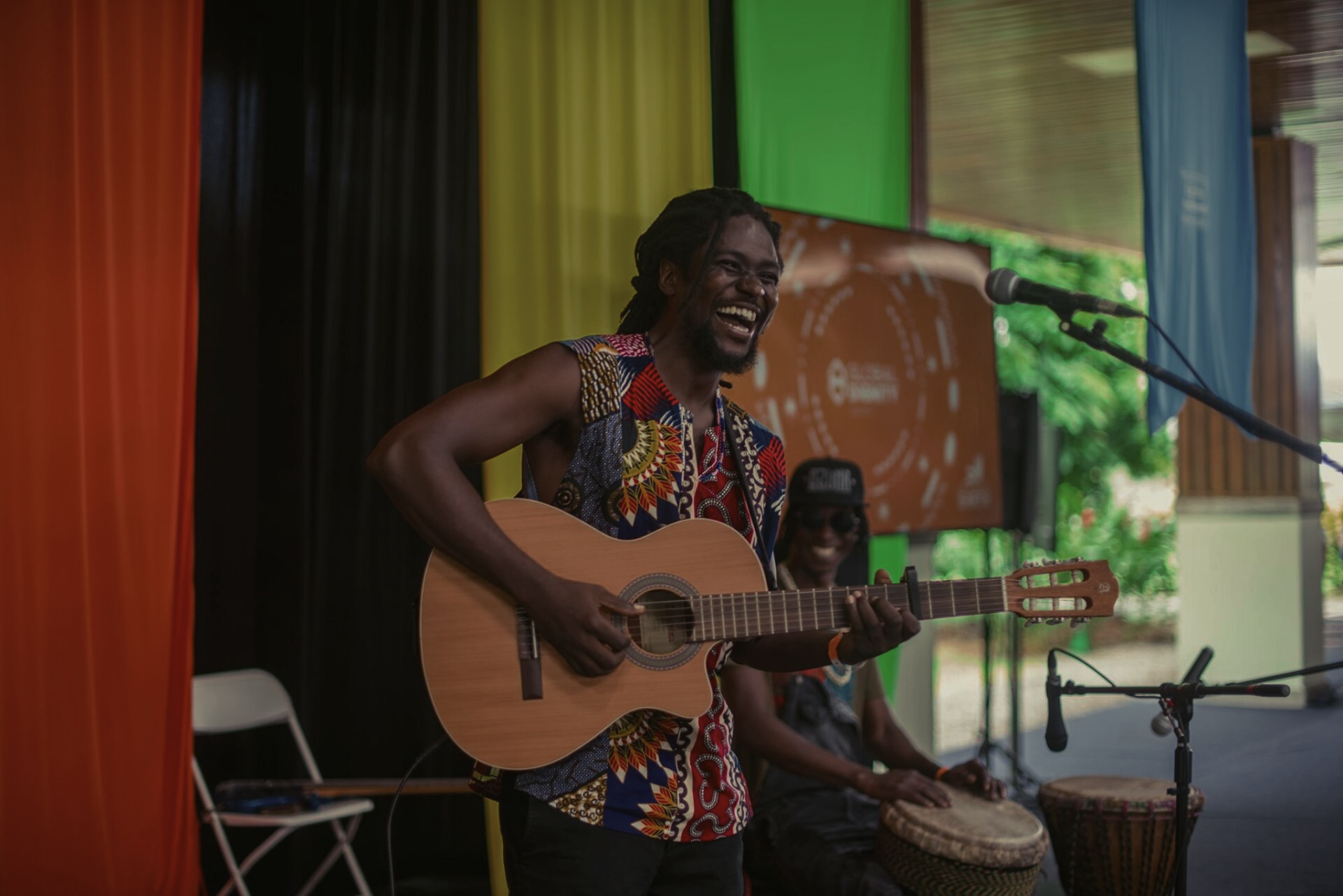 A man is playing a guitar and singing into a microphone.