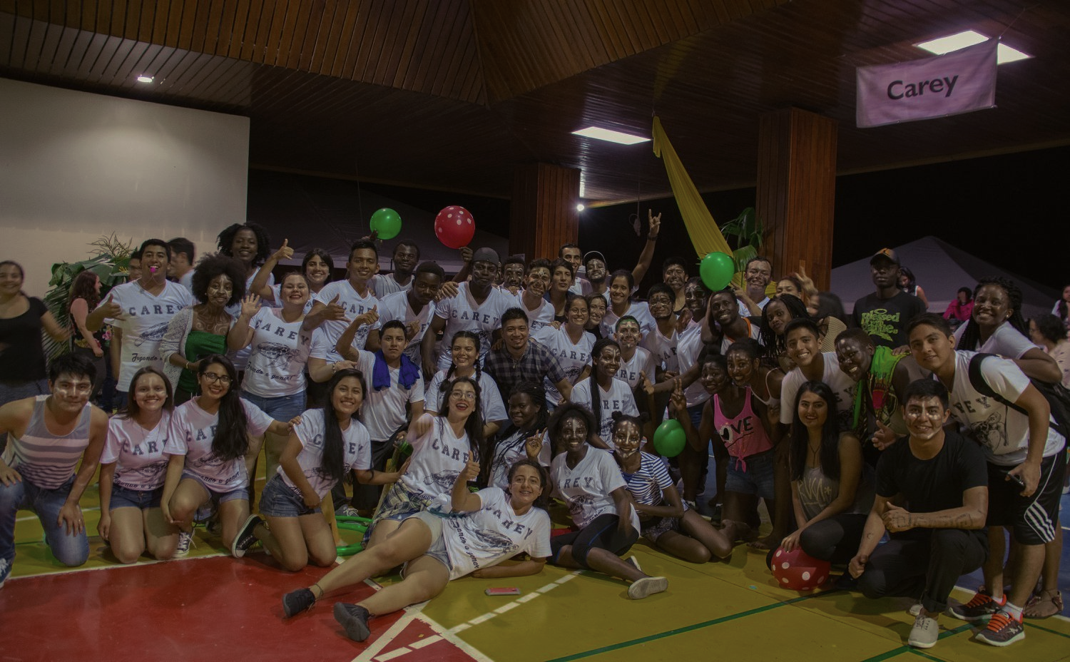 A large group of people are posing for a picture in a gym.
