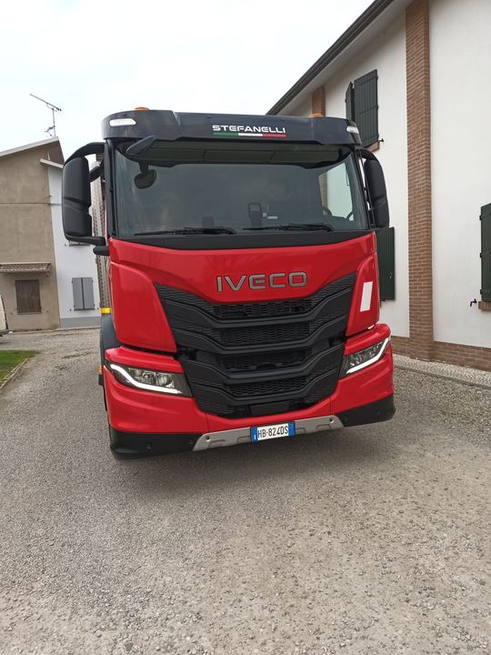 Camion che pompa acqua da un tombino aperto su una strada bagnata