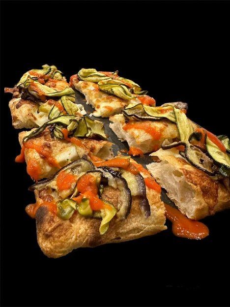Fette di pizza con verdure su sfondo nero