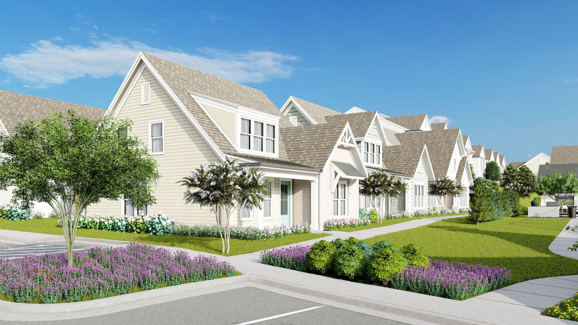 Row of light-colored houses with gabled roofs and landscaped front yards on a sunny day.