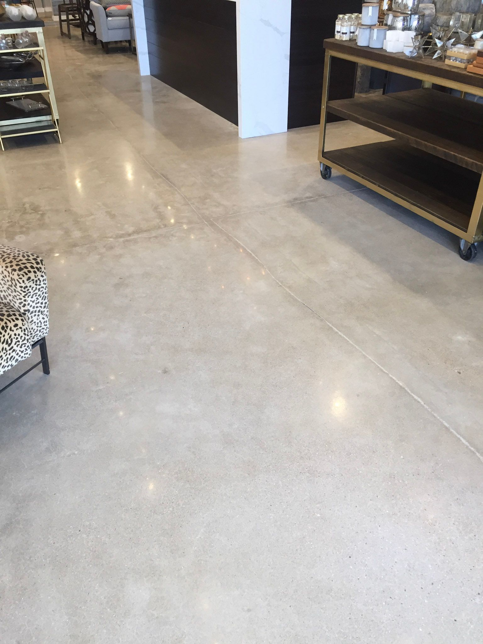 a polished concrete floor in a room with a table and chairs .