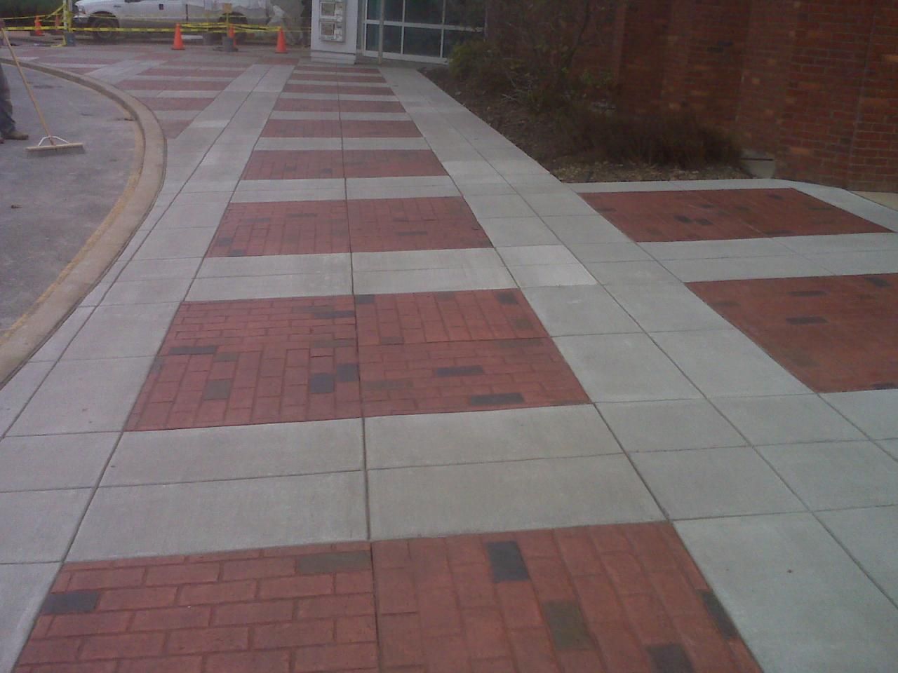 a  stamped concrete  sidewalk with red and white bricks on it