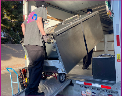 A man is loading a refrigerator into a truck.