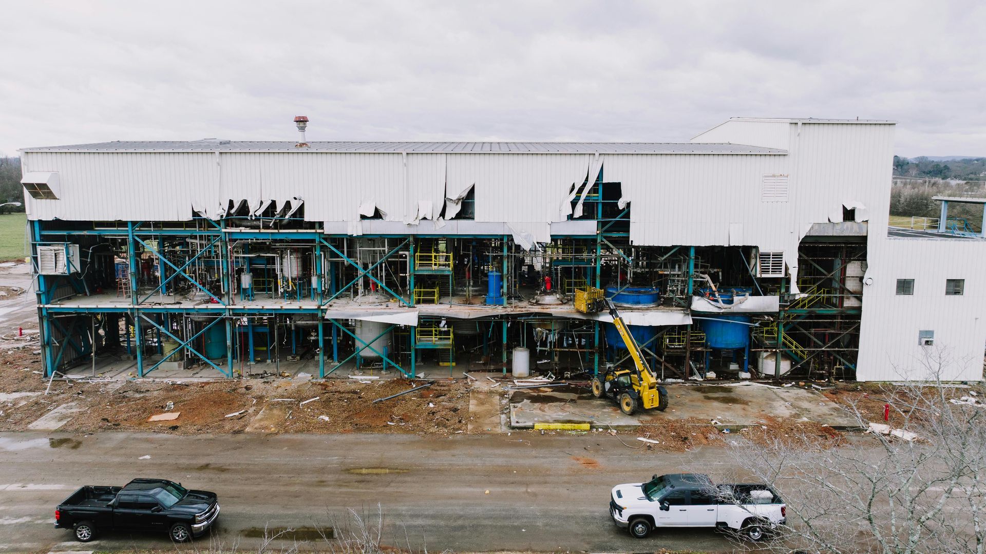 An aerial view of a building under construction with cars parked in front of it.