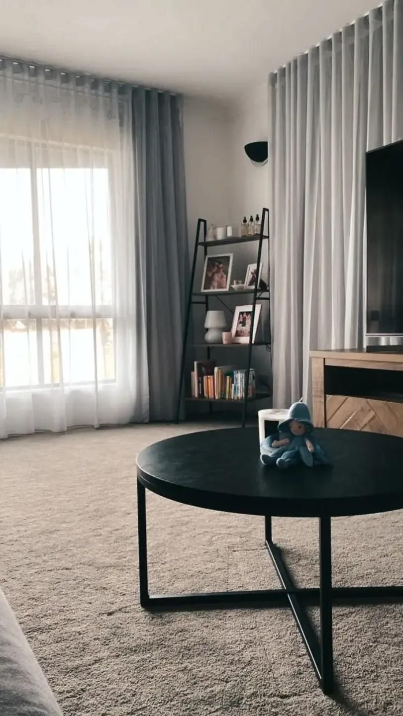 A Living Room With a Round Coffee Table and a Television — Mi-ekka Designs in Cannonvale, QLD