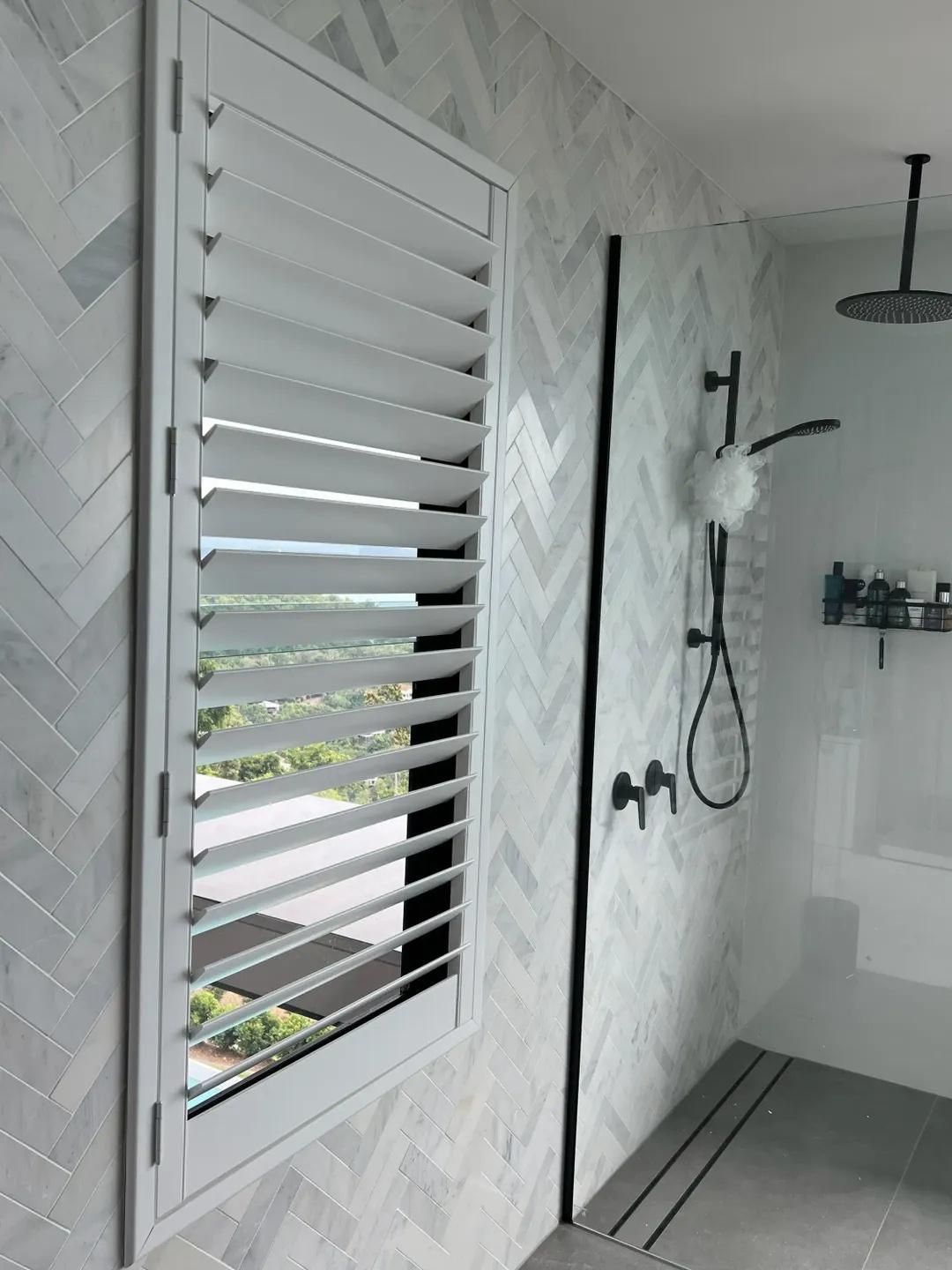 A Bathroom With a Shower and a Window With Shutters — Mi-ekka Designs in Cannonvale, QLD