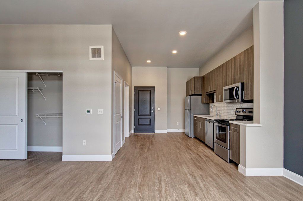 An empty apartment with a kitchen and a closet at Daymark Uptown Apartments.