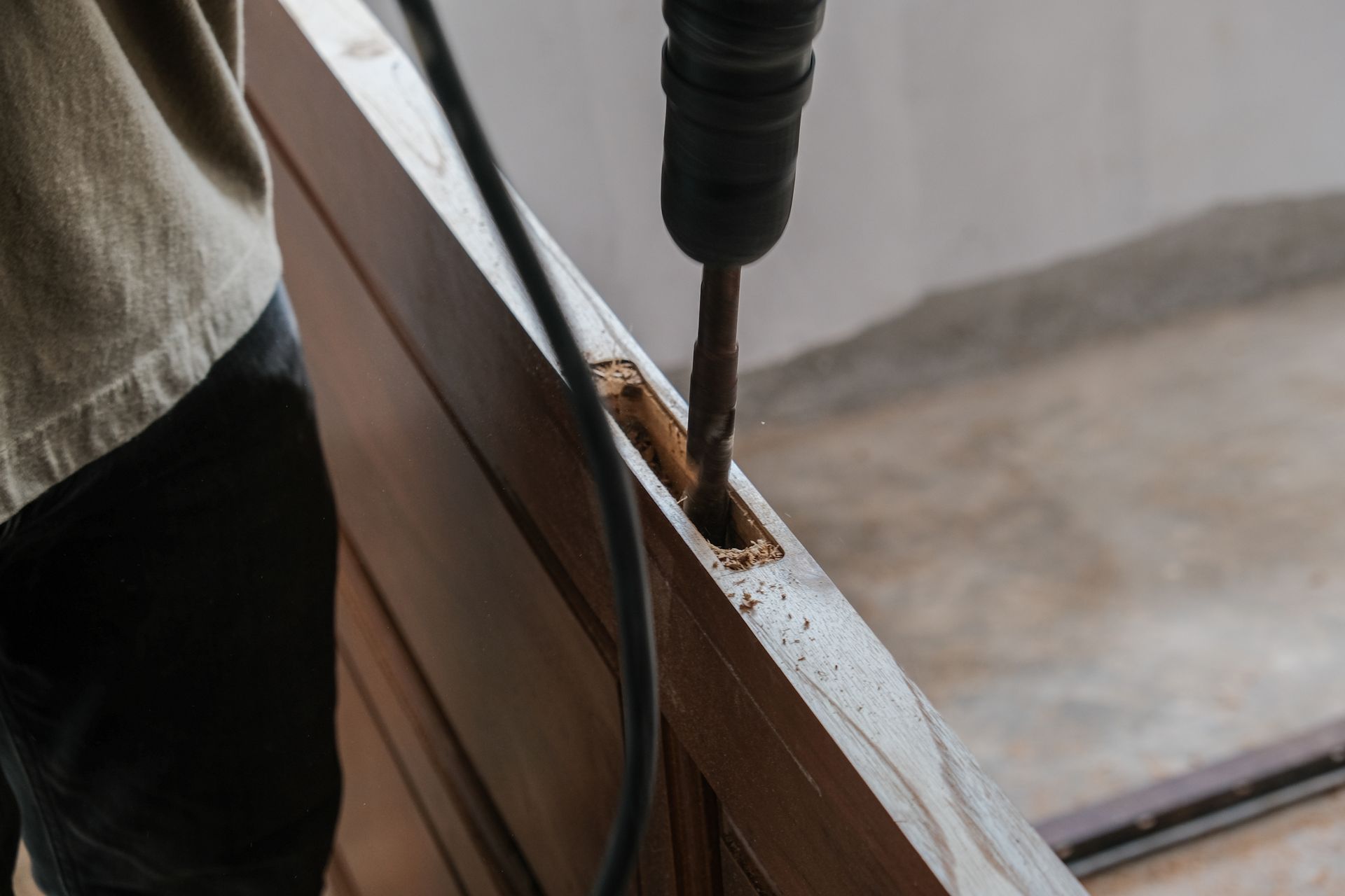 Hand drill boring a hole in a wooden frame during construction work