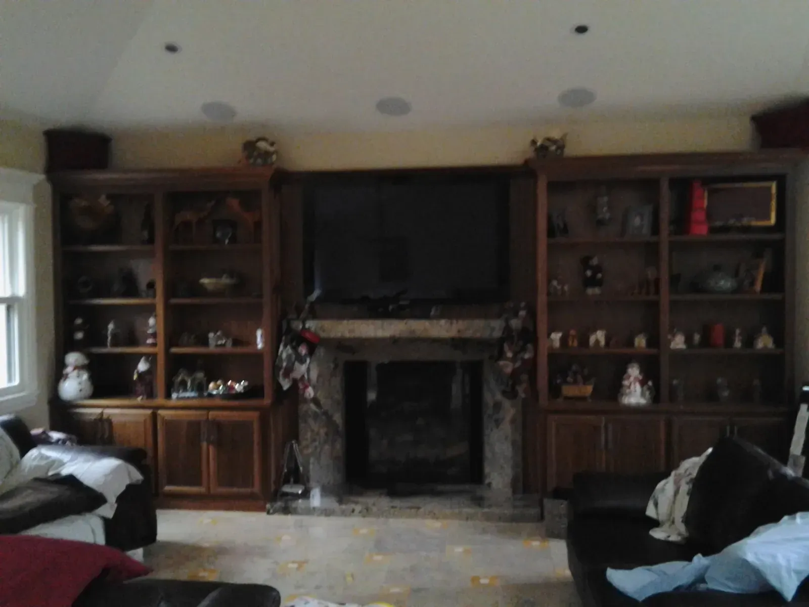Living room with a fireplace, TV, and built-in wooden shelves on both sides.