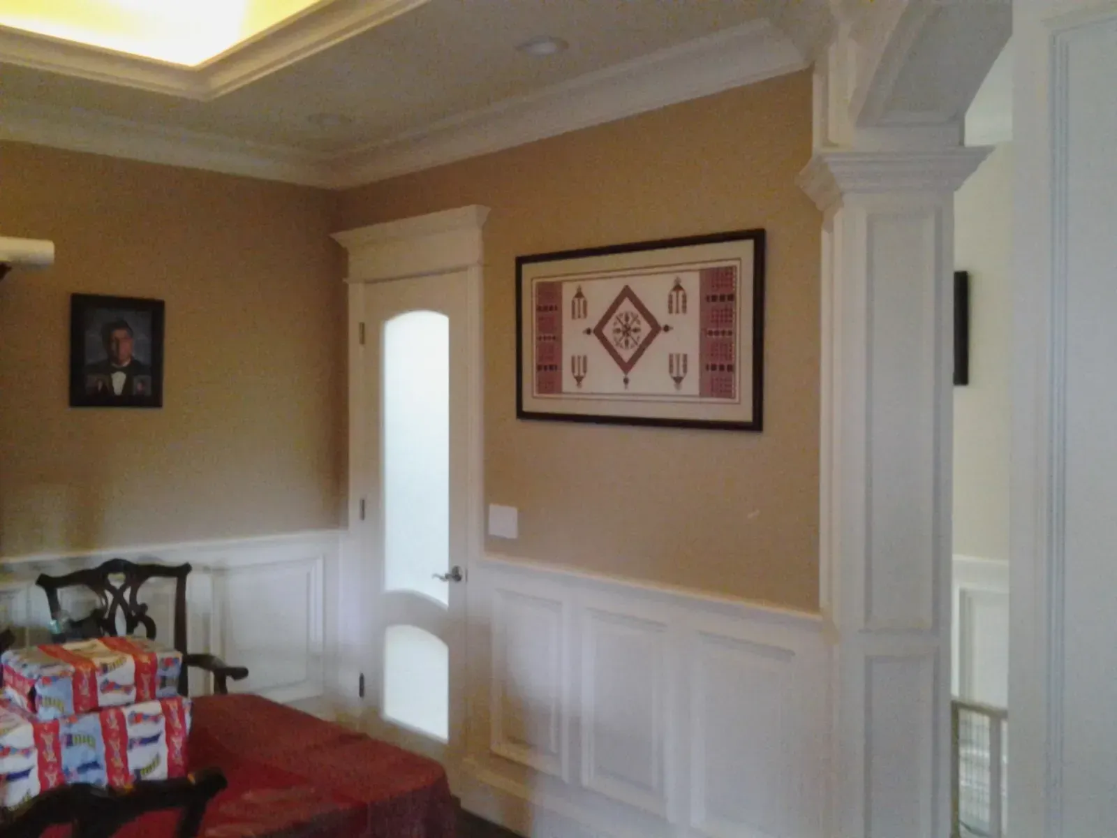 Living room with beige walls, white trim, red sofa, and framed wall art.