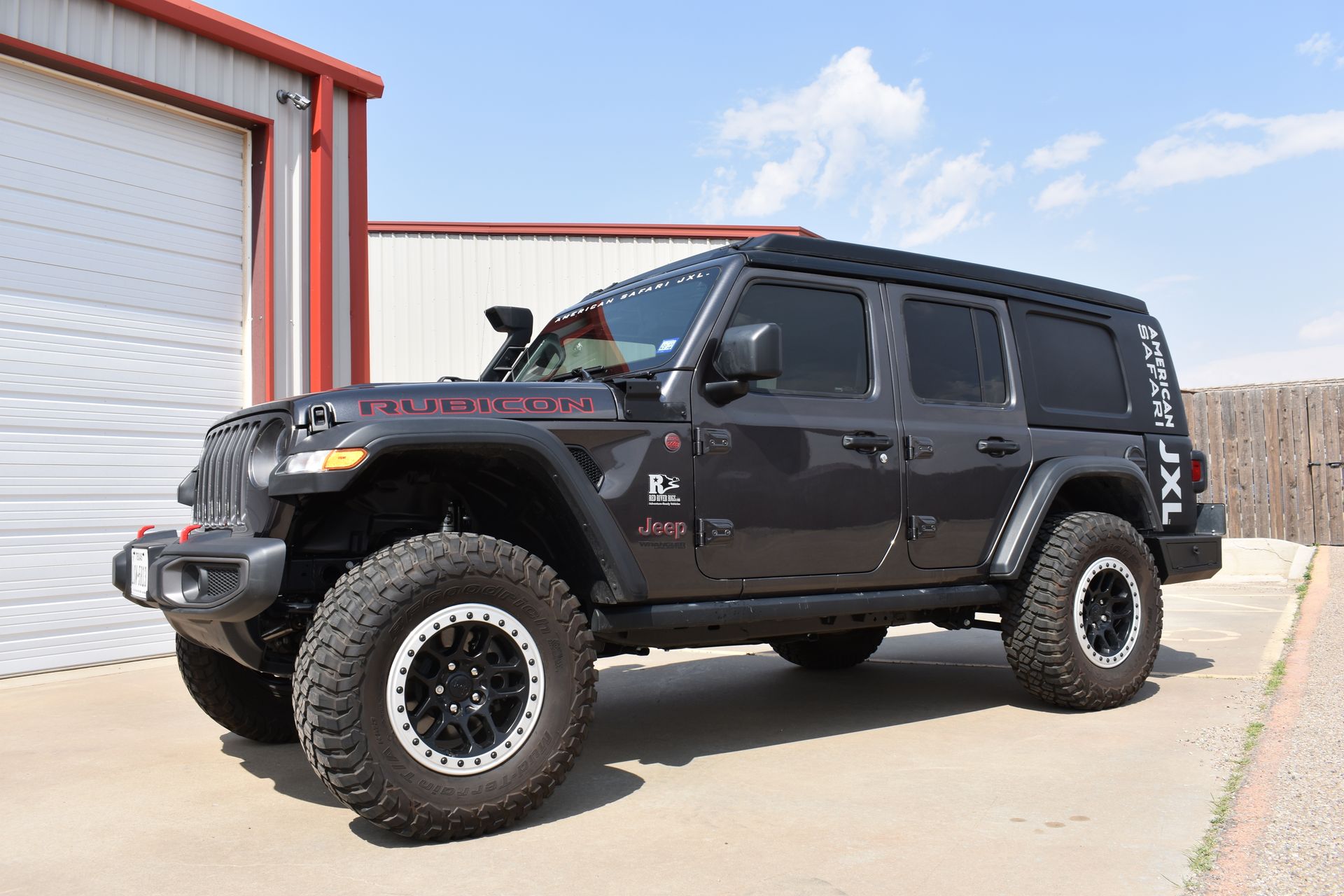 A grey American Safari JXL is parked in front of a garage.