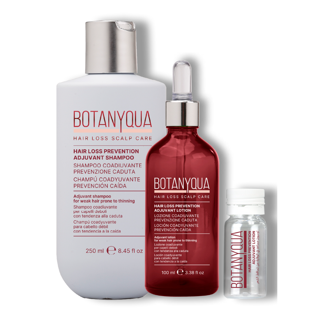 una grande bottiglia bianca di shampoo, una bottiglia rossa di siero con contagocce e una piccola fiala.