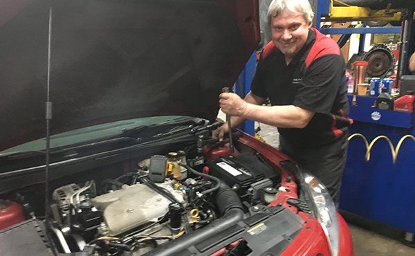 Mechanic Fixing The Engine — Fort Wayne, IN — Summit Transmission Inc Mechanic Fixing The Engine — Fort Wayne, IN — Summit Transmission Inc