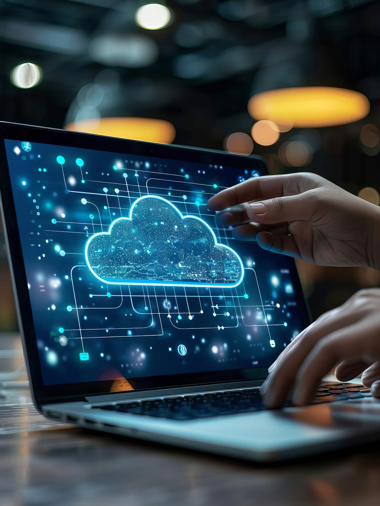 A person is typing on a laptop with a cloud on the screen.