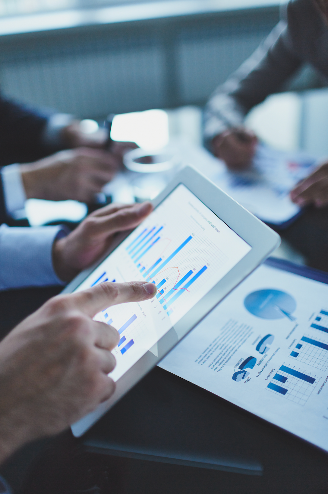 A person is pointing at a graph on a tablet