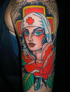 Traditional nurse tattoo with red cross headpiece, blue eyes, red rose, and dagger on forearm by Absolute Art Tattoo Richmond