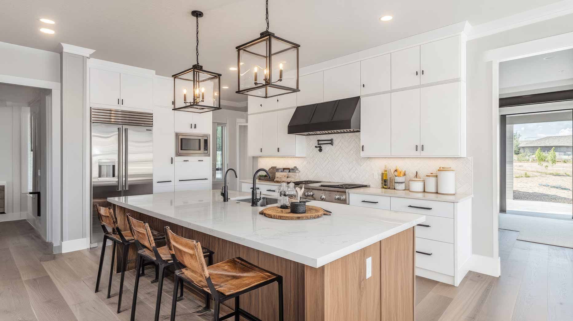 Bright modern white kitchen with island, black pendant lights, and wooden bar stools