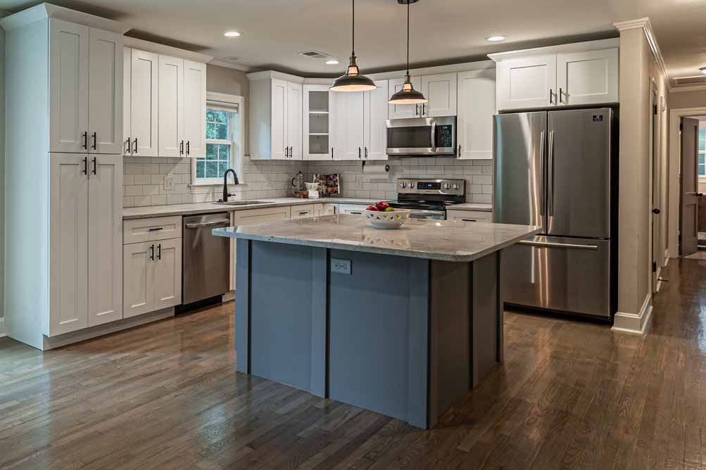 Modern kitchen with white cabinets, stainless steel appliances, and a large blue island with granite countertop
