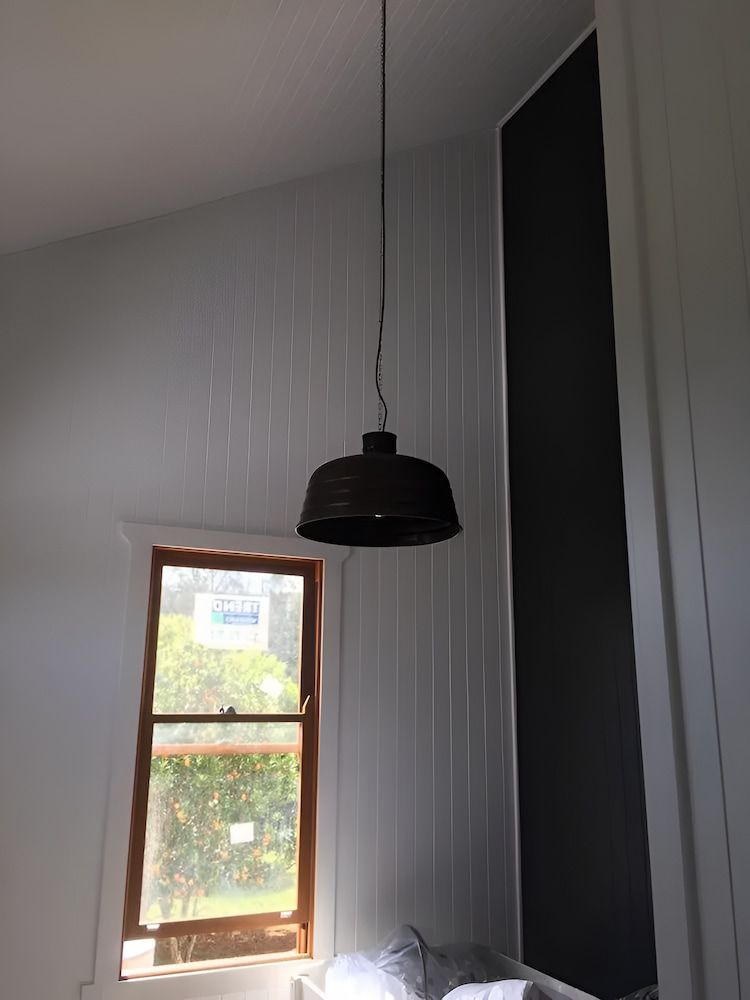 A Lamp Is Hanging From The Ceiling In A Room Next To A Window — In-Line Electrical Southern Highlands in Carrick, NSW