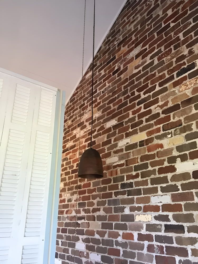 A Brick Wall With A Pendant Light Hanging From It — In-Line Electrical Southern Highlands in Carrick, NSW