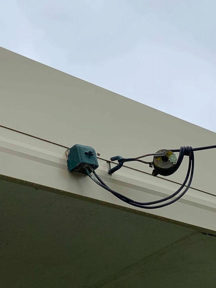 A Bunch Of Wires Are Hanging From The Side Of A Building — In-Line Electrical Southern Highlands in Carrick, NSW
