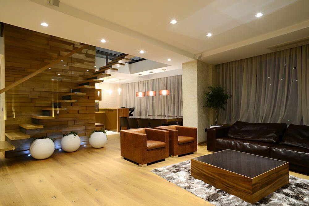 A Living Room With A Couch, Chairs, Coffee Table And Stairs — In-Line Electrical Southern Highlands in Goulburn, NSW