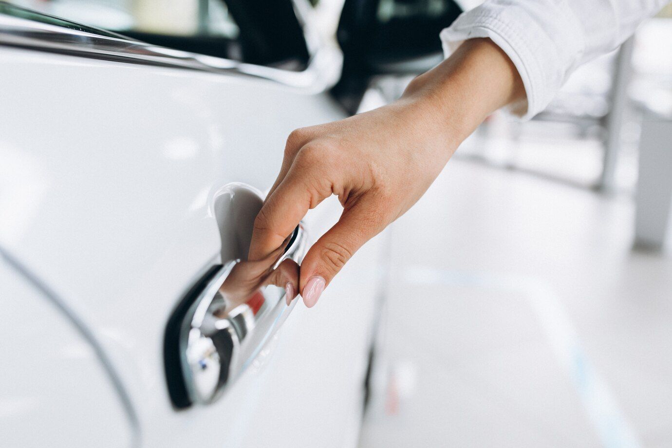 Una mujer abre la puerta de un coche blanco.
