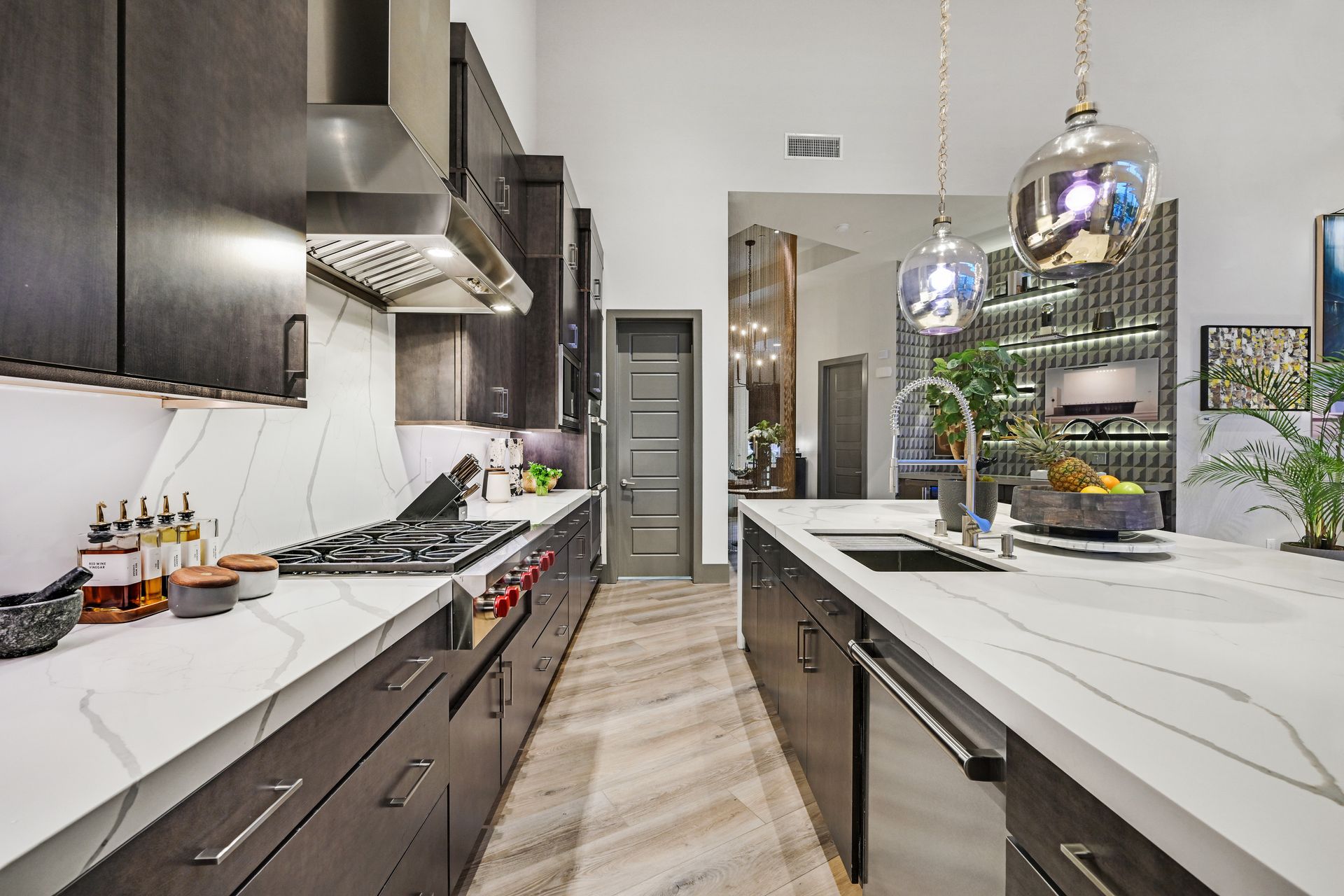 Modern kitchen with dark cabinetry, white countertops, and stainless steel appliances.