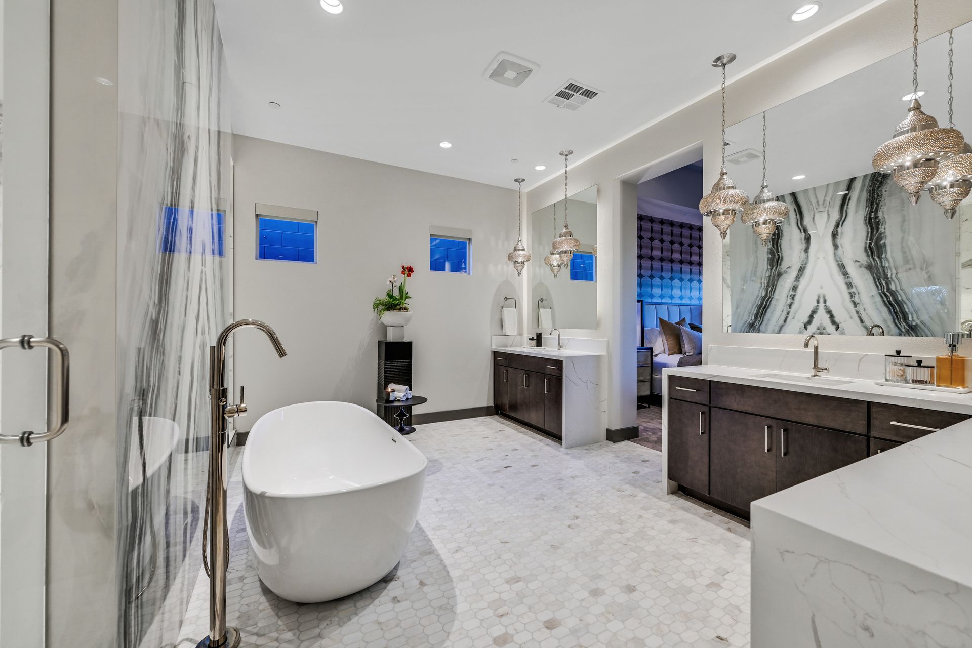 Luxurious bathroom with soaking tub, double sinks, and marble tile.