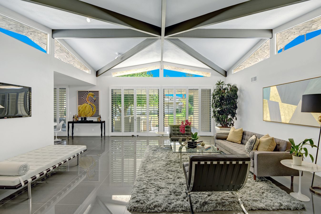 A living room with a couch , chairs , and a rug.