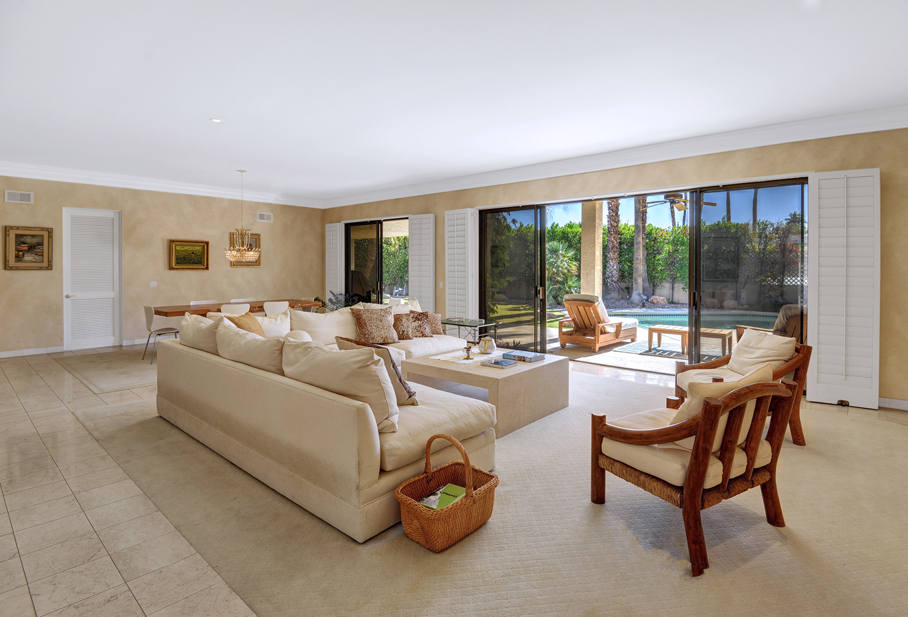 A living room with a couch , chairs and a basket of grapes.