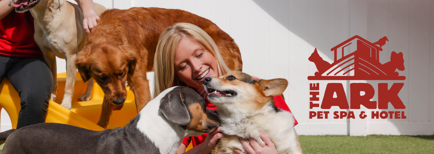 A woman is petting a dog in front of a pet spa and hotel logo.