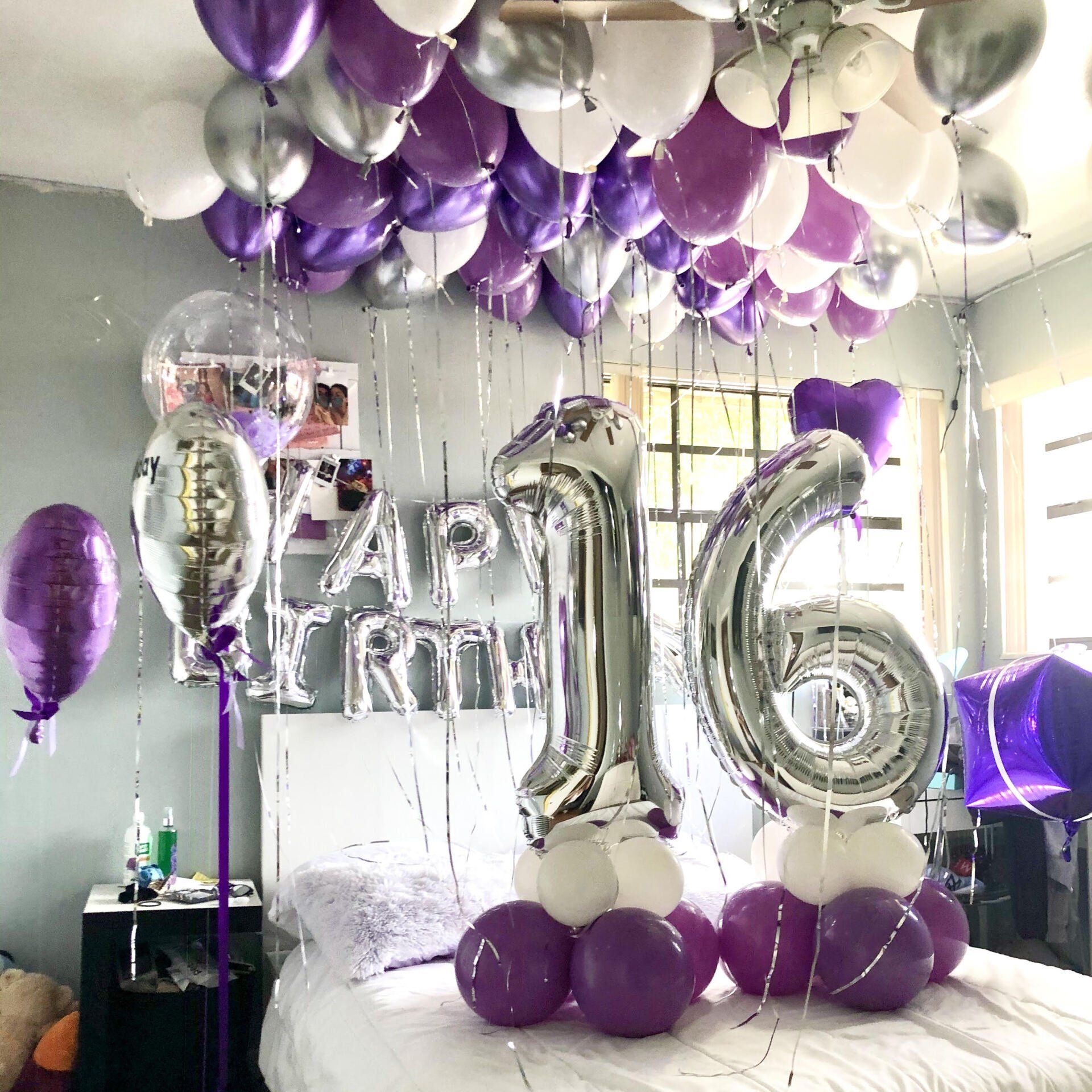 Room decorated with purple, silver, and white balloons for a Sweet Sixteen celebration. Silver number balloons and 