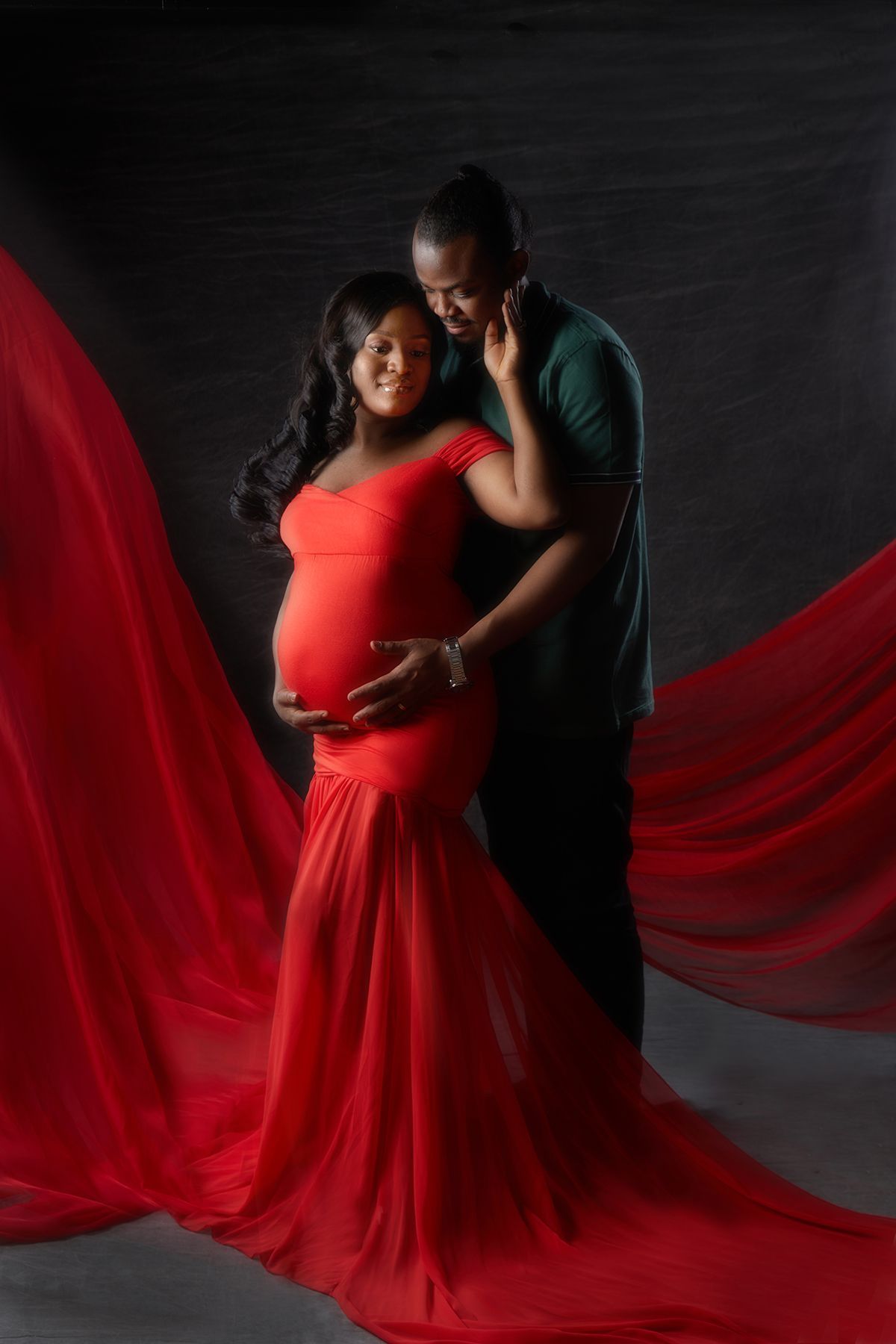 Couple sharing a tender moment during a maternity photoshoot at Oakley Studios, Luton