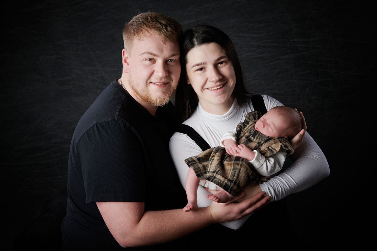Young couple cradling their newborn baby during a portrait session at Oakley Studios, Luton