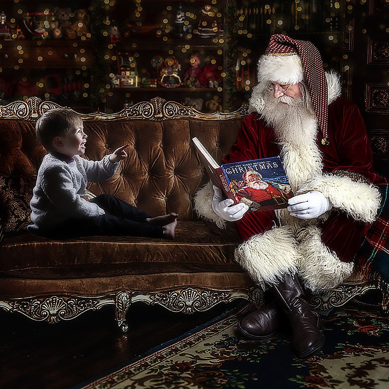 a small boy sitting with a digital Santa during a magical Christmas photoshoot at Oakley Studios, Luton and Dunstable border