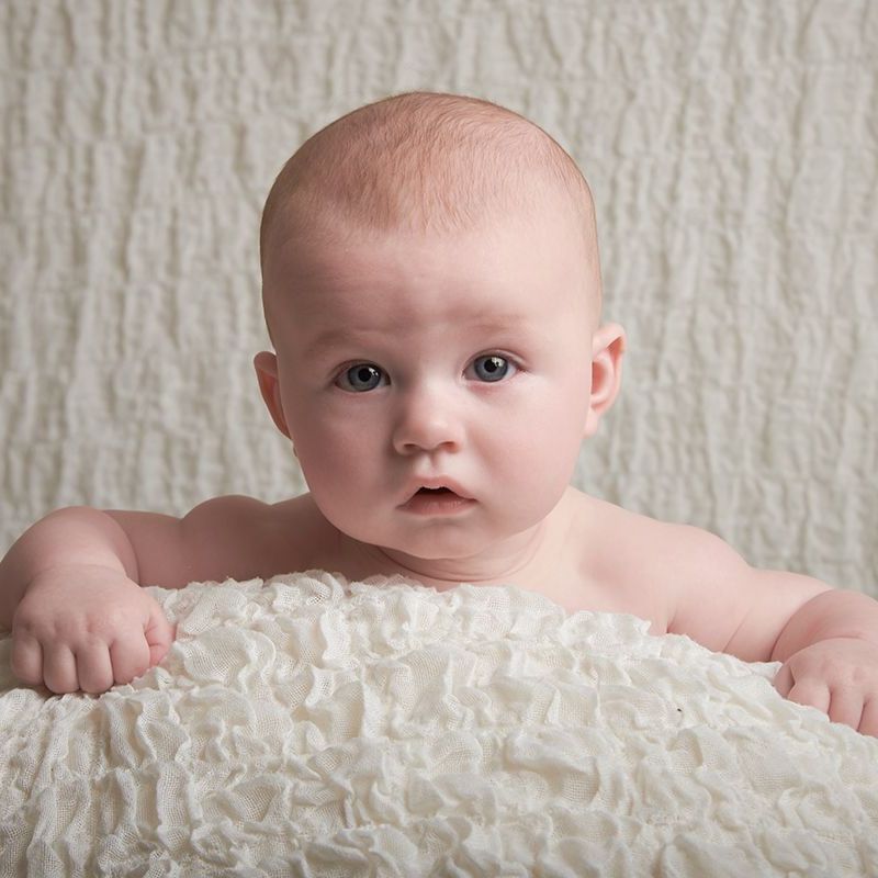 Four-month-old baby during tummy time at a baby portrait session at Oakley Studios, Luton and Dunstable border