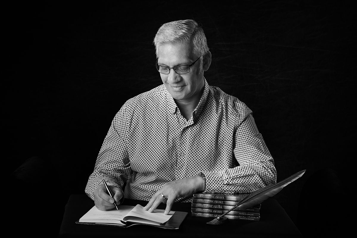 Author Darrell Gregory writing at his desk — RAF veteran and author portrait by Oakley Studios, Luton and Bedfordshire