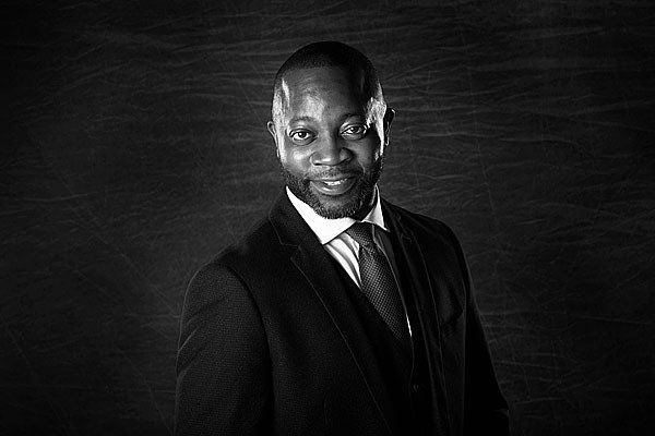 A black and white photo of a man in a suit and tie.