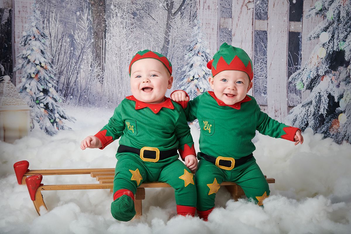 Twin children in a Christmas snow scene during a festive photoshoot at Oakley Studios, Bedfordshire