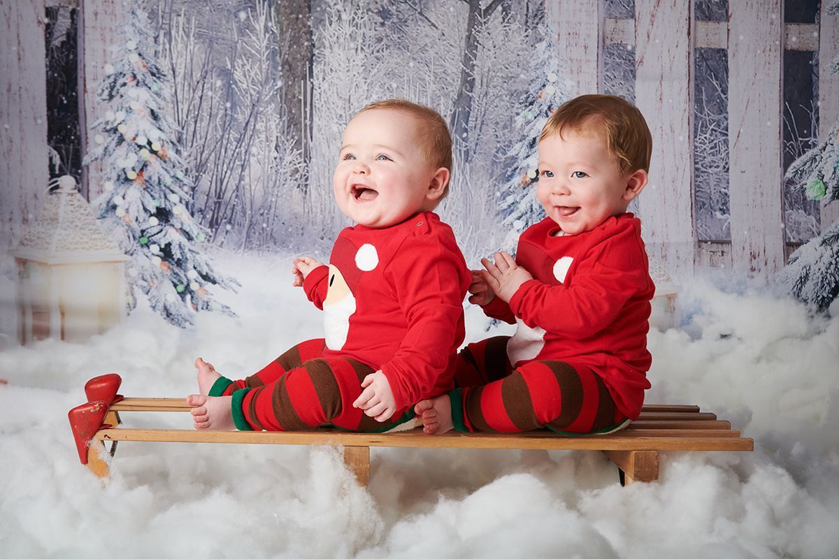 Twin children in a Christmas snow scene during a festive photoshoot at Oakley Studios, Bedfordshire