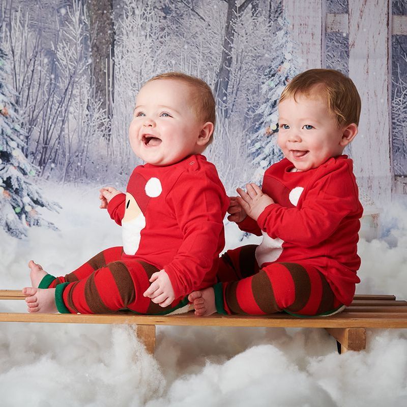 Twin children in a Christmas snow scene during a festive photoshoot at Oakley Studios, Bedfordshire