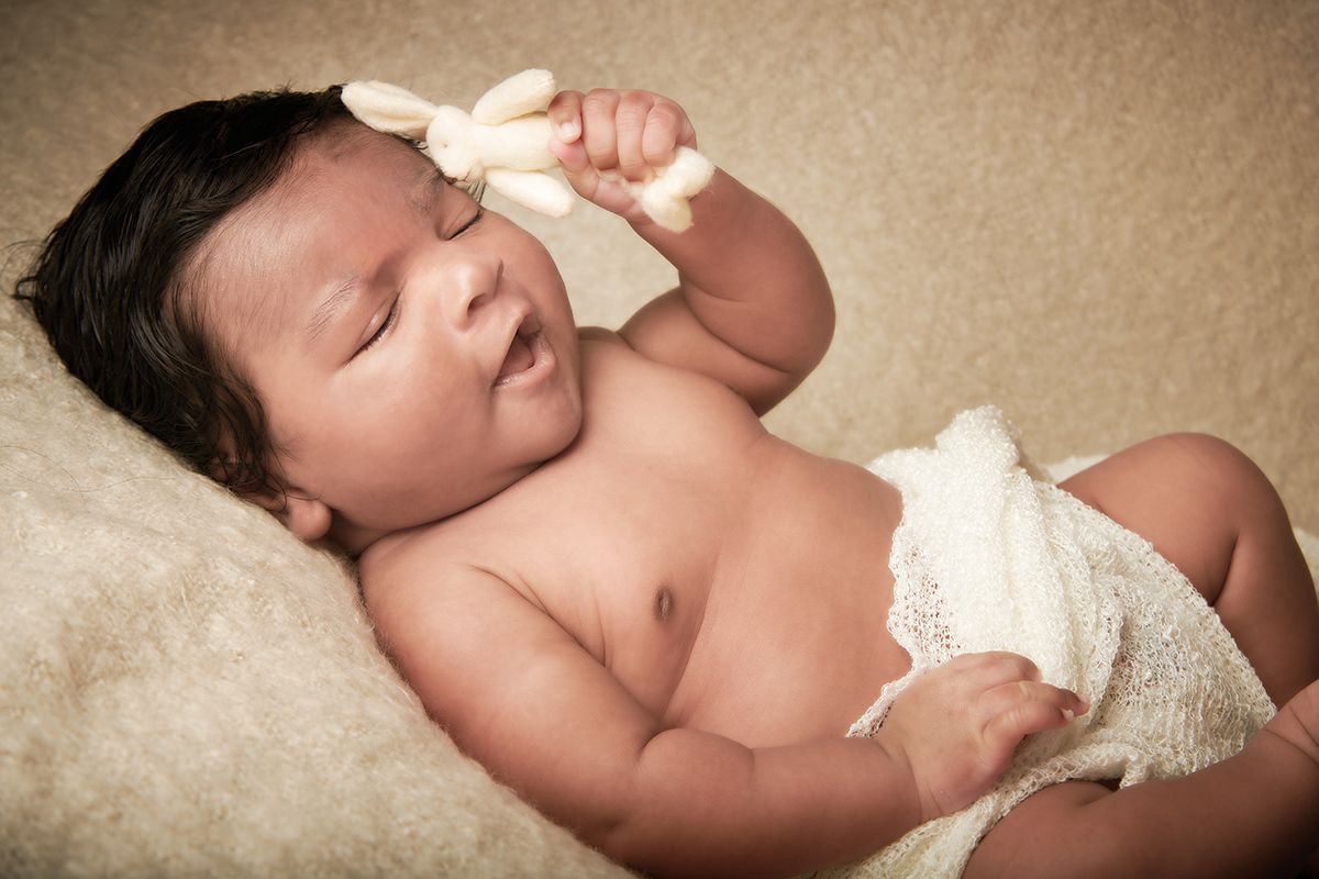 newborn baby with eyes closed holding soft toy Oakley Studios , Luton Bedfordshire