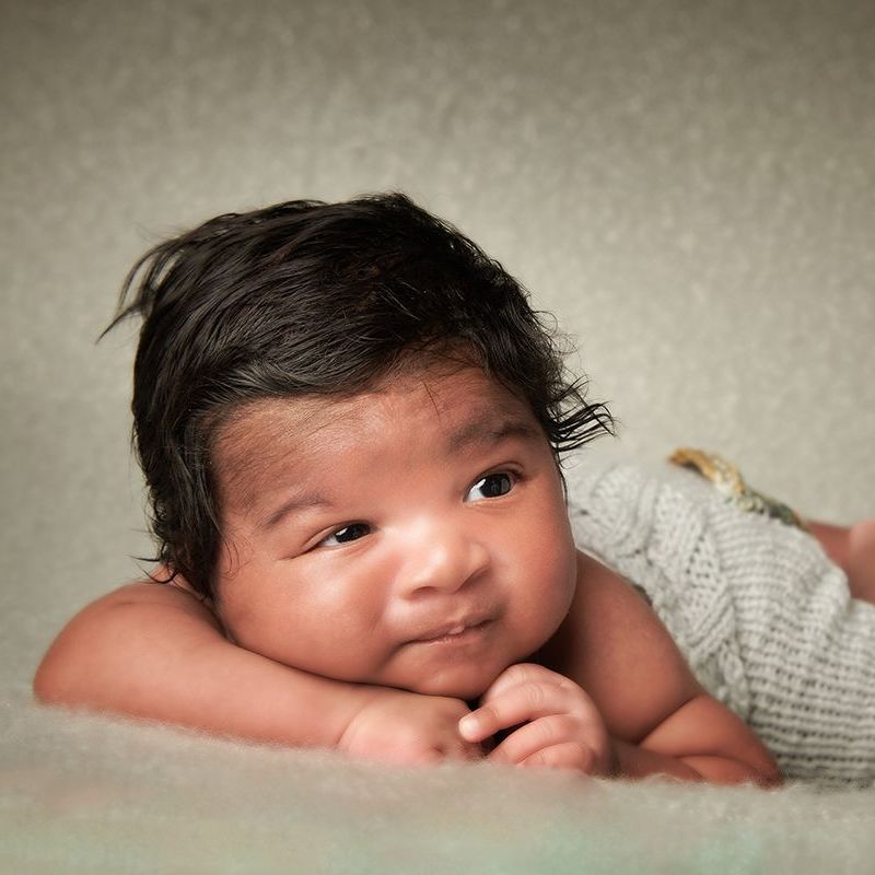 Newborn awake on cream background Oakley Studios