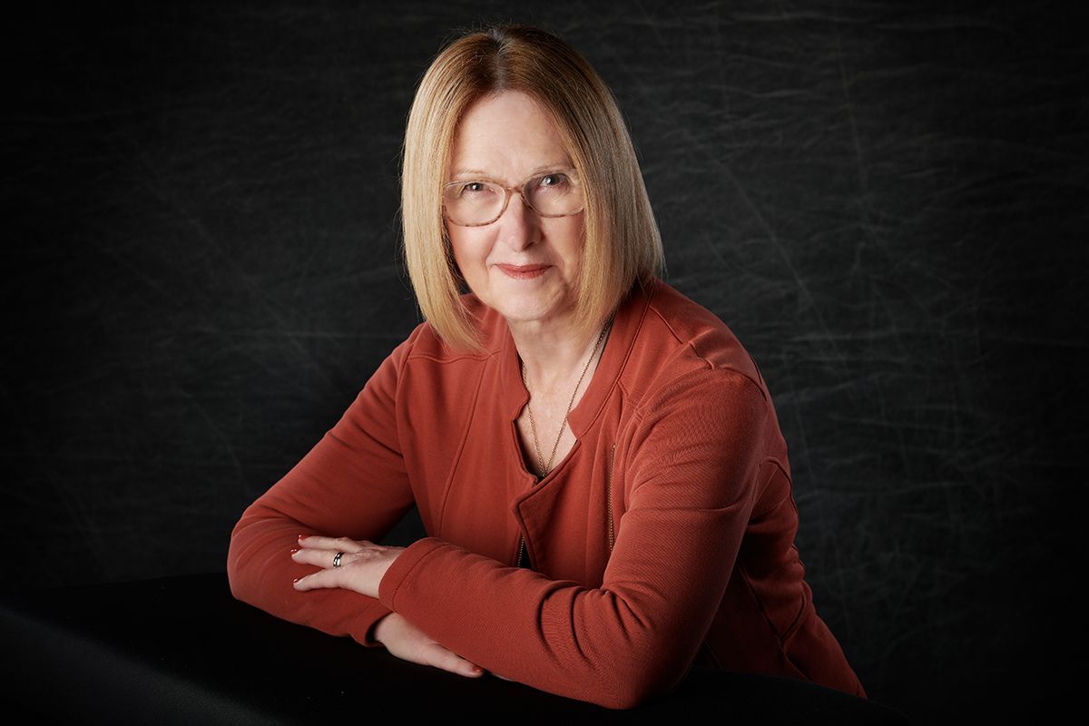 Professional headshot of a confident woman in glasses and a red sweater — Oakley Studios, Luton and Dunstable border