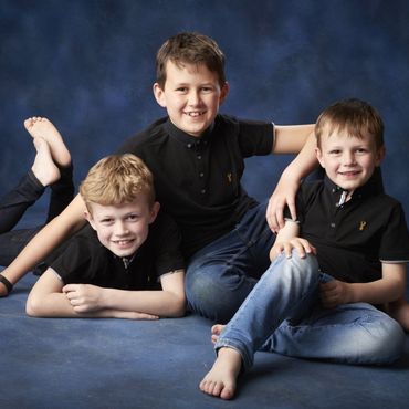 Three brothers in casual outfits posing for a children's portrait session at Oakley Studios, Bedfordshire