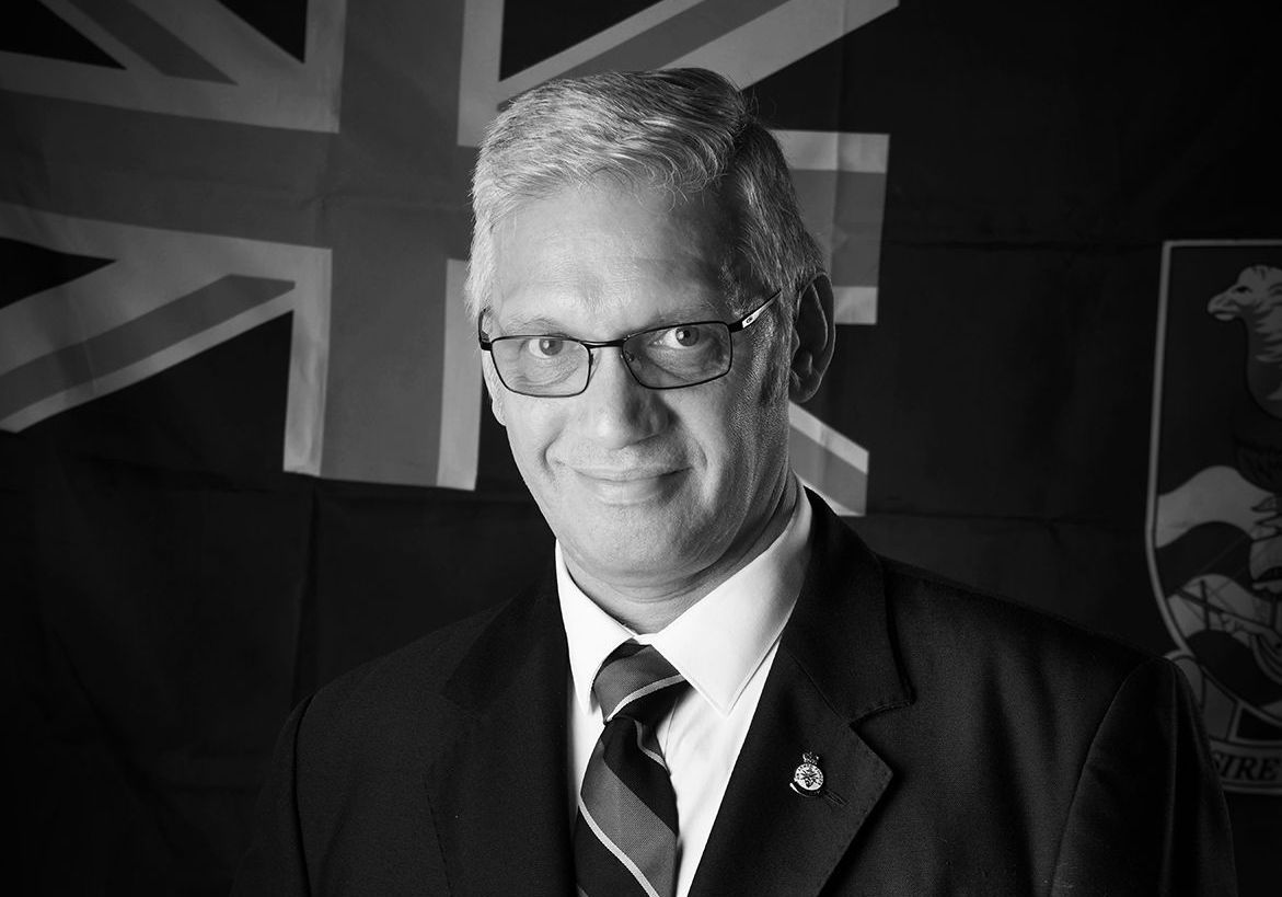 Darrell Gregory standing in front of a British flag during his RAF veteran author headshot session at Oakley Studios, Luton