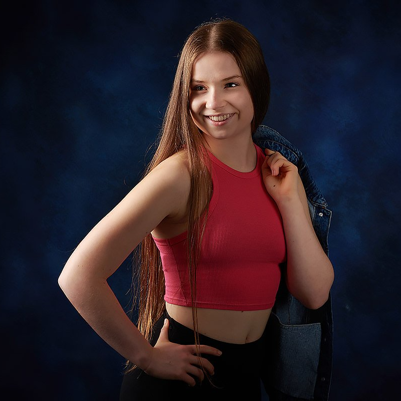 A woman wearing a red crop top and a denim jacket